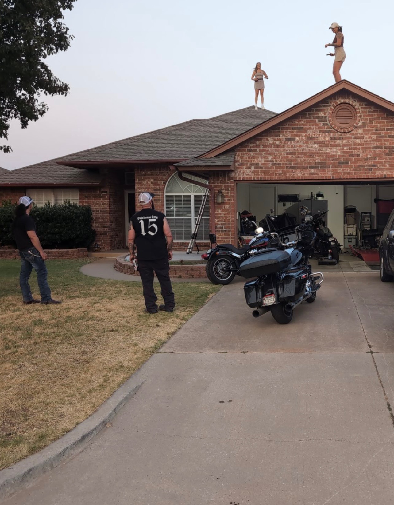 Neighbors watching as the team inspects a roof at dusk