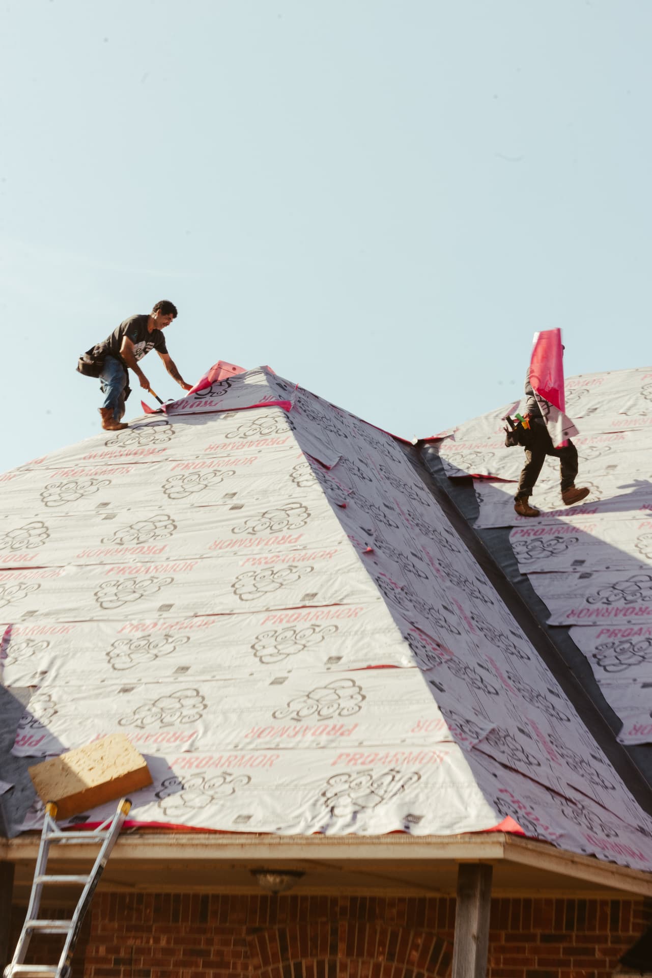 Two crew members finishing the ridge wrap