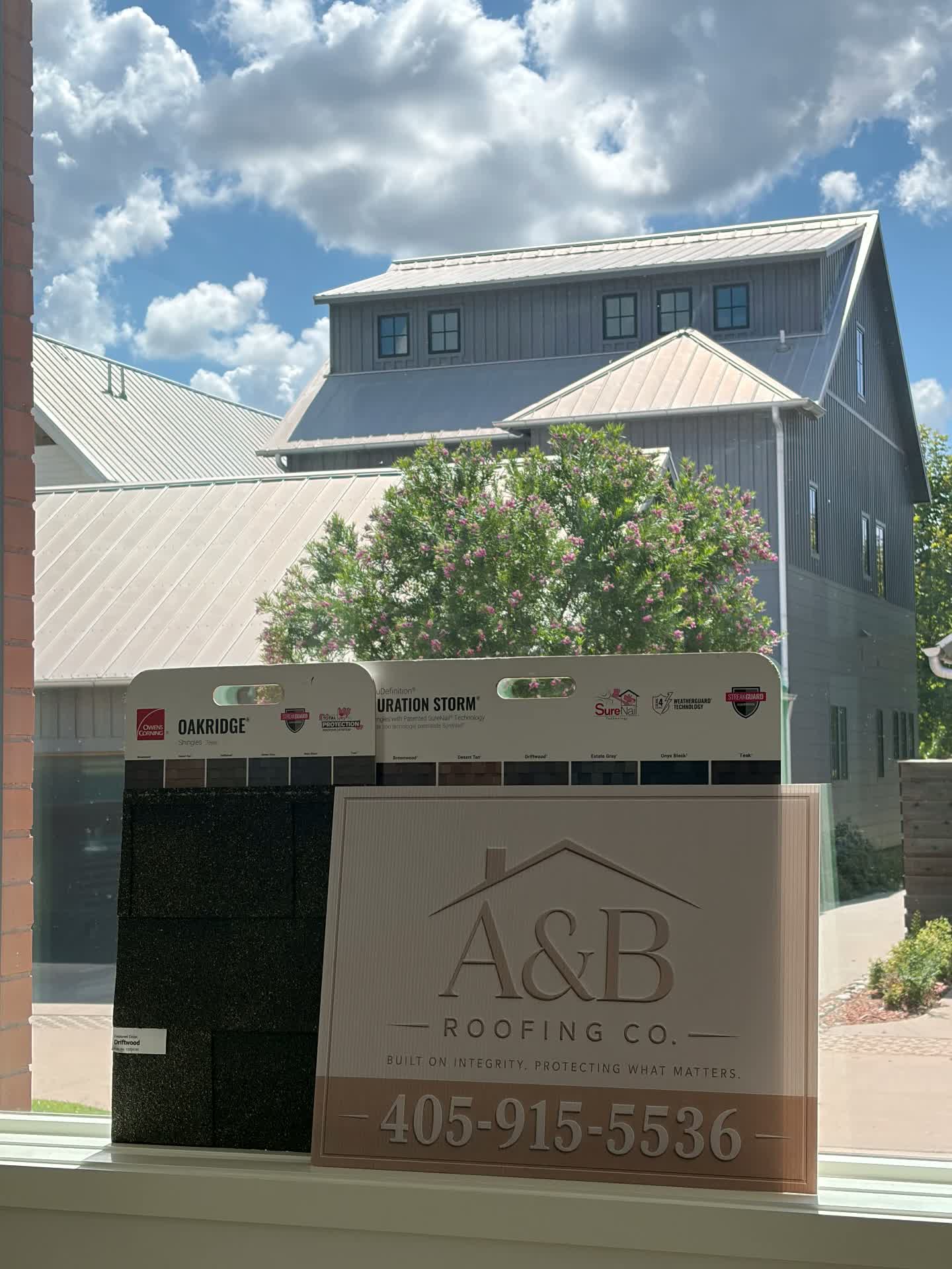 A yard sign and shingle samples in the office window