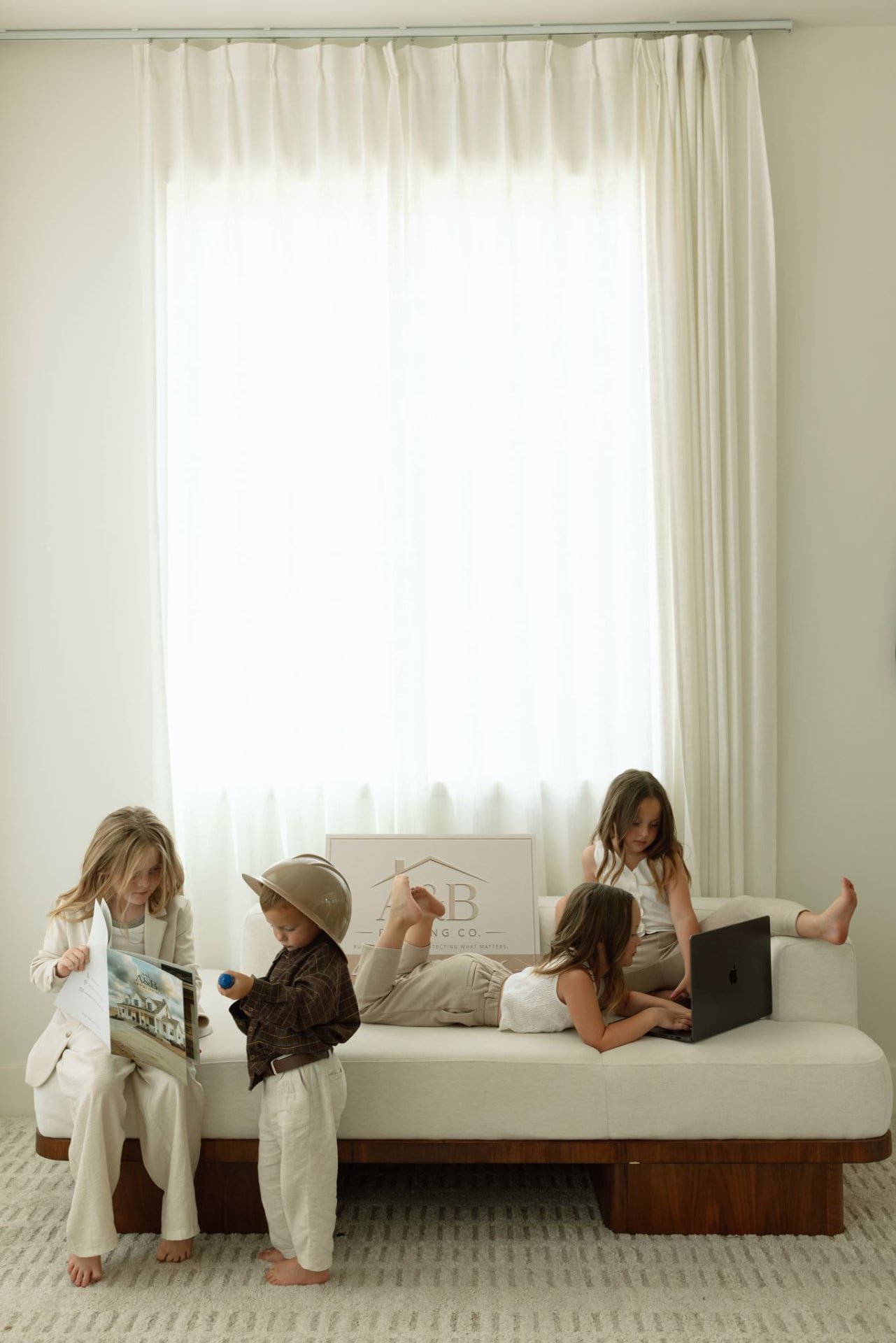 Ameilla and Brooklynn's children at home with the A&B Roofing Co. sign