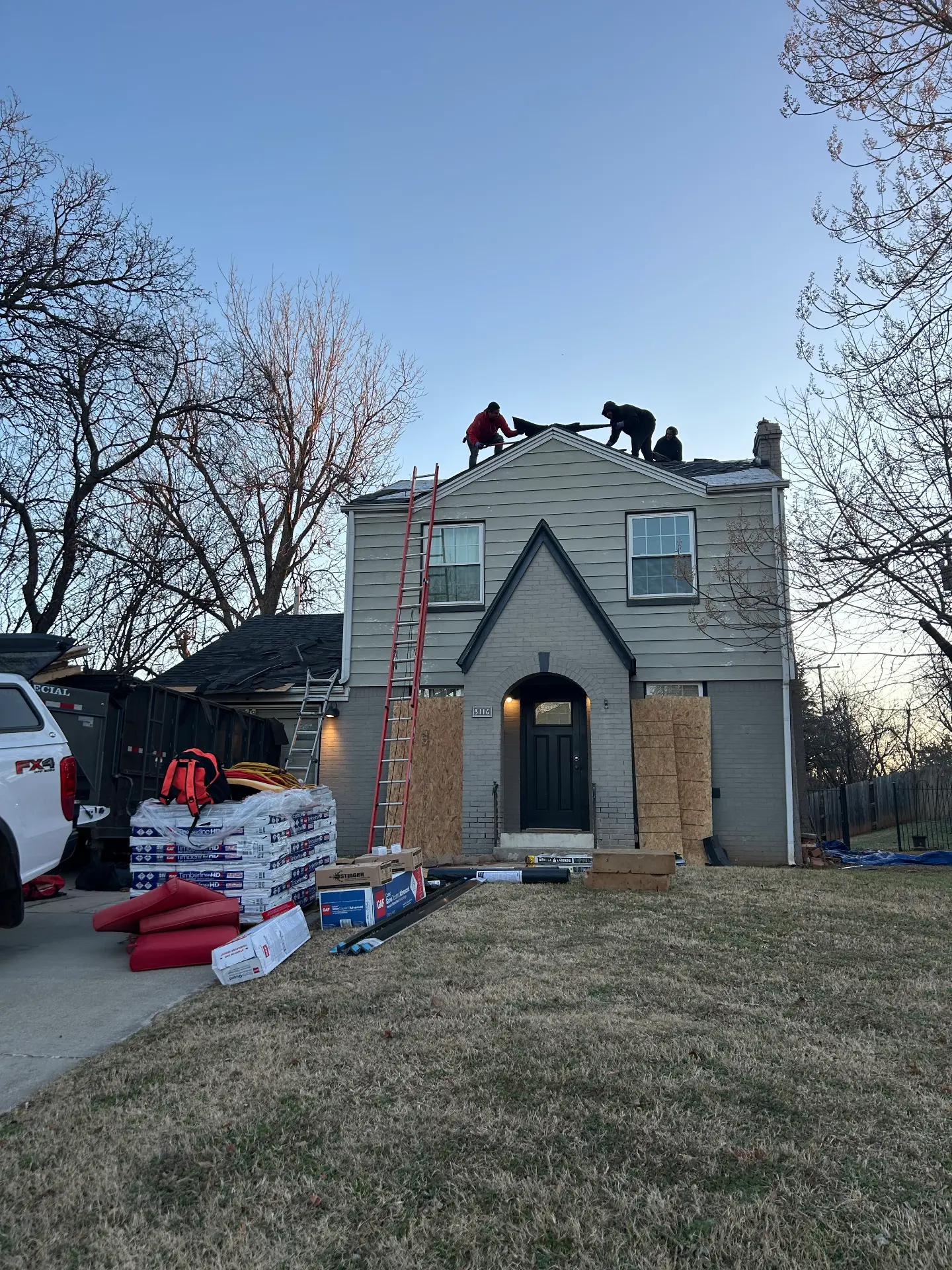The crew finishing a roof at dusk