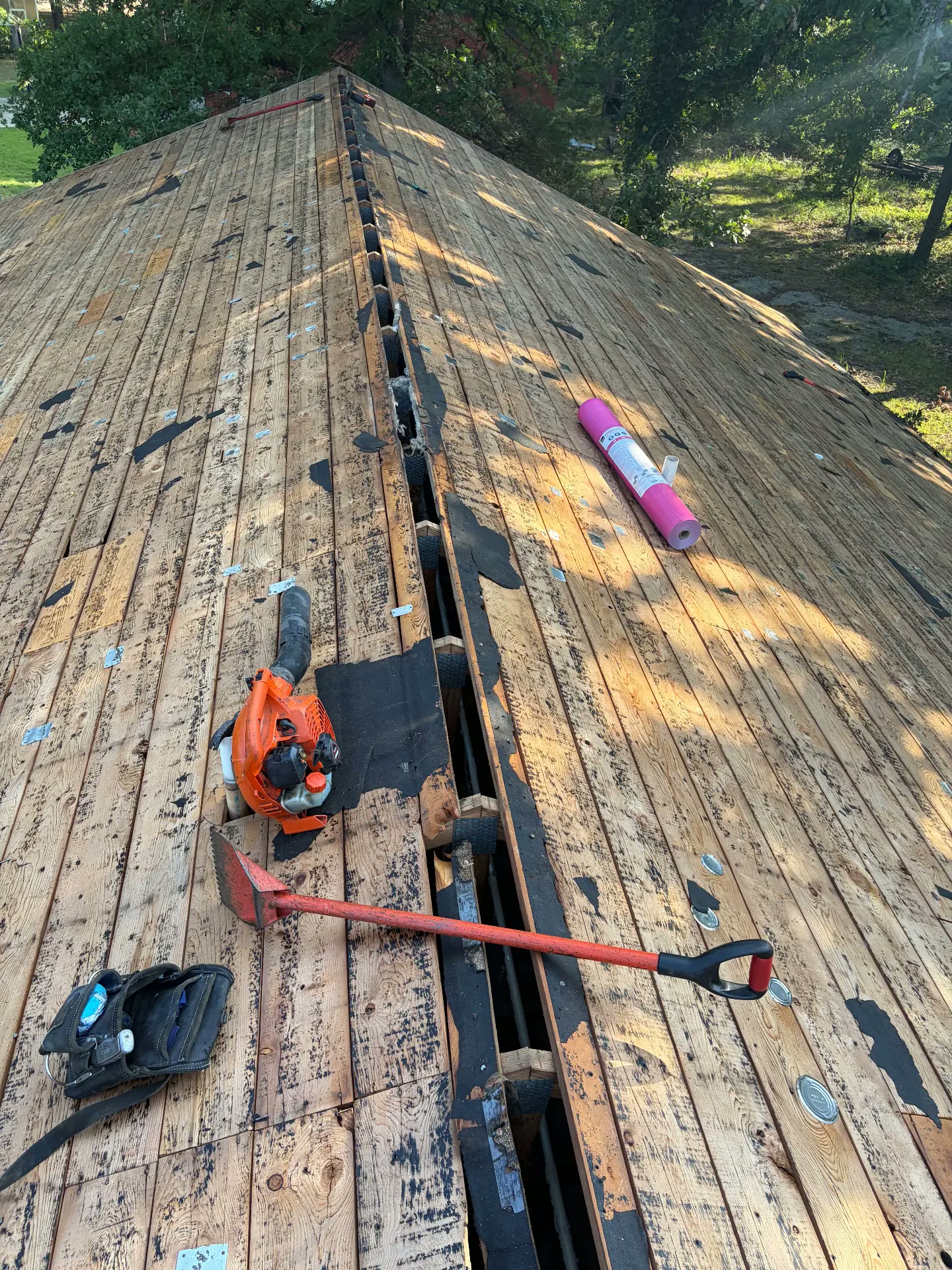 A crew working through a tear off on a roof deck