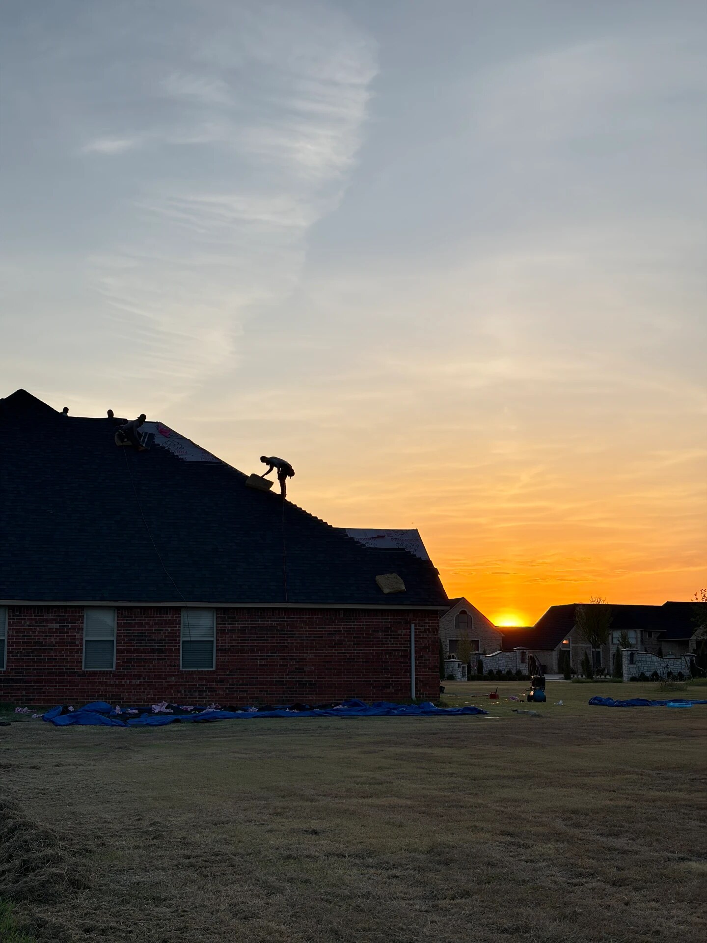 Finishing a roof against an Oklahoma sunset