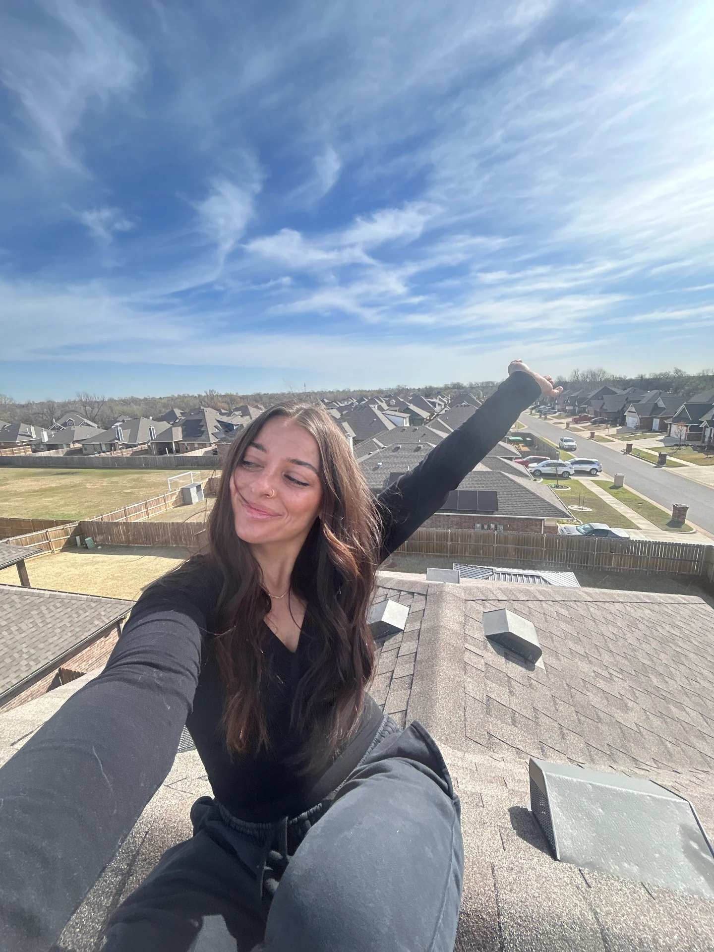 Arms up on the rooftop above the neighborhood